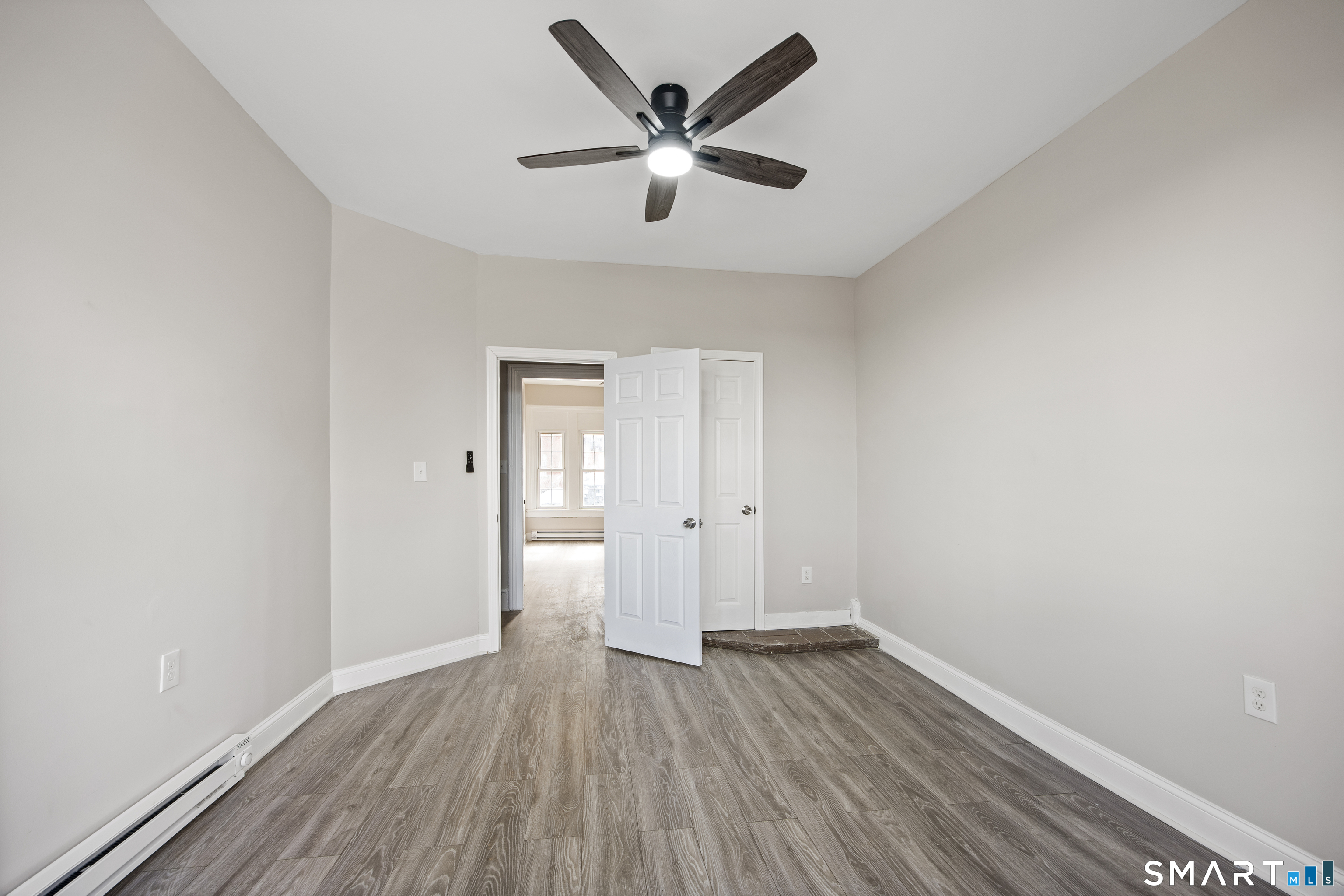 465 Washington Avenue Waterbury, CT 06708 - Photo 8 of 34 an empty room with wooden floor and a ceiling fan