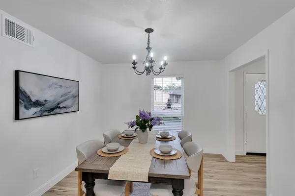 a view of a dining room with furniture wooden floor and a chandelier