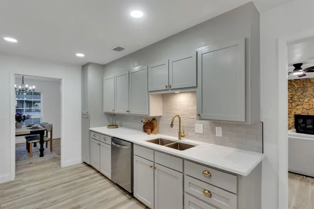 a kitchen with a sink cabinets and wooden floor