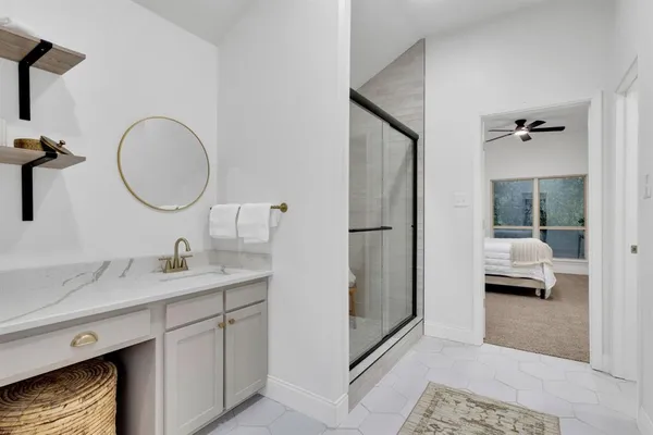 a en suite bathroom with a granite countertop sink and a mirror