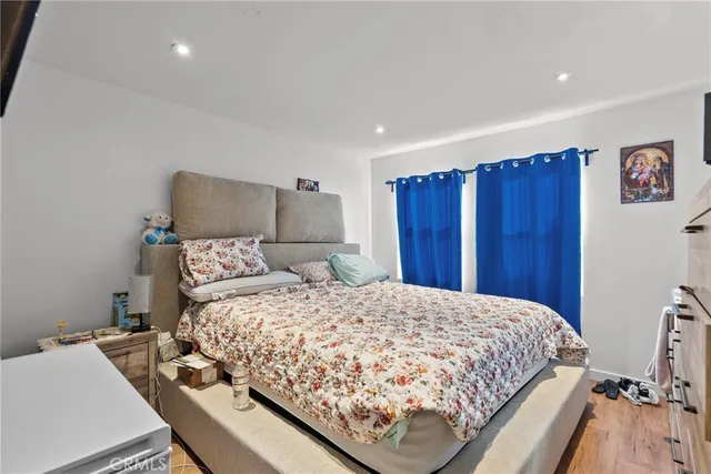 a bedroom with a bed and wooden floor