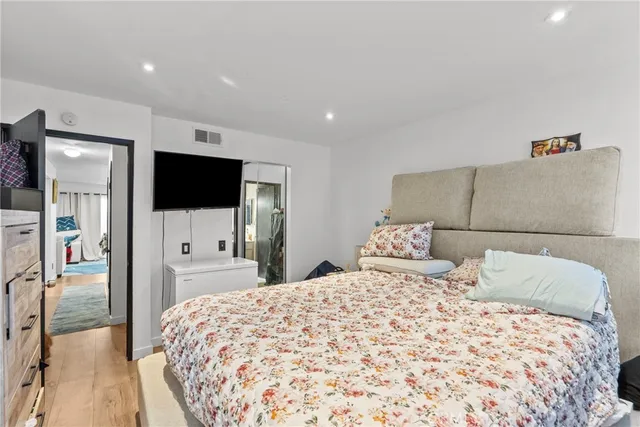 a large bedroom with a bed and a flat screen tv