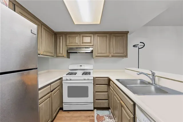 a kitchen with stainless steel appliances granite countertop a sink stove and refrigerator