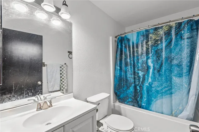 a bathroom with a sink vanity mirror and toilet