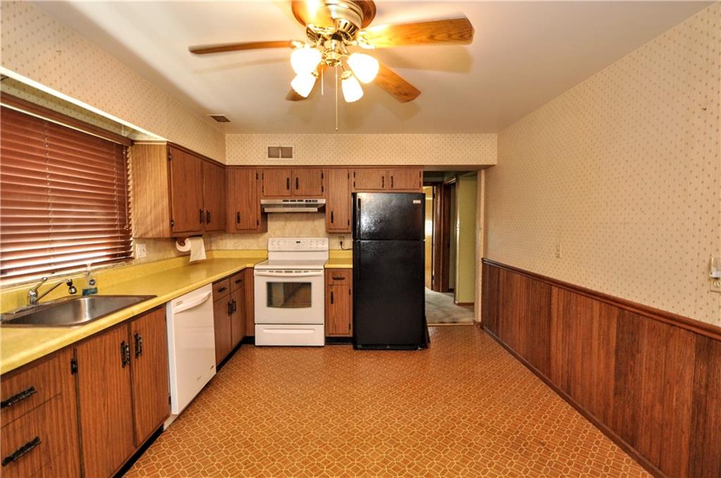 880 Peairs Road Elizabeth, PA 15037 - Photo 9 of 33 a kitchen with stainless steel appliances granite countertop a refrigerator a sink dishwasher a stove and a dining table with wooden floor