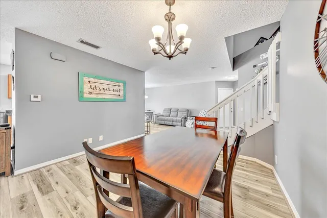 a living room with furniture kitchen view and a chandelier