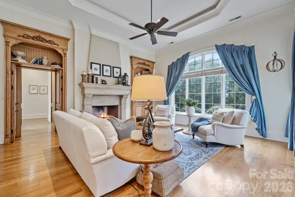 a living room with fireplace furniture and a large window
