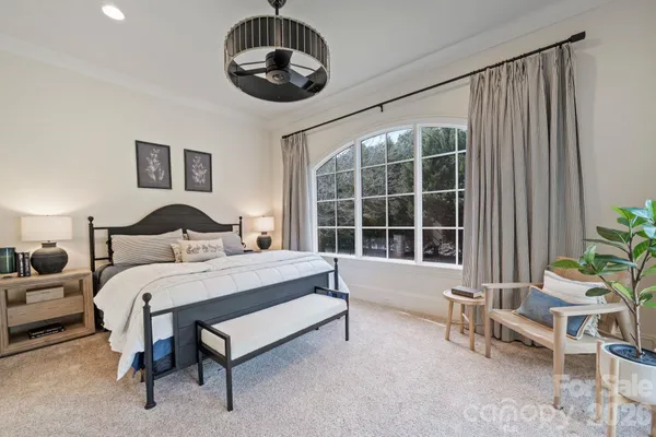 a spacious bedroom with a bed and a large window