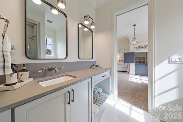 a spacious bathroom with a sink double vanity granite and a mirror