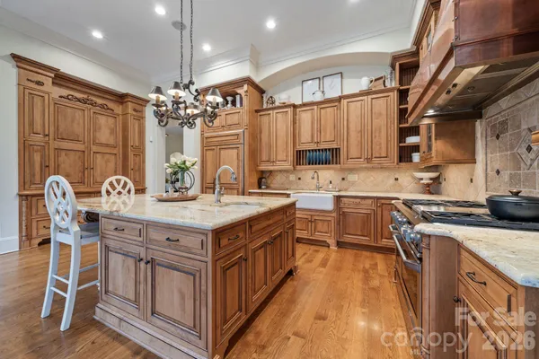 a kitchen with stainless steel appliances granite countertop a sink stove and cabinets