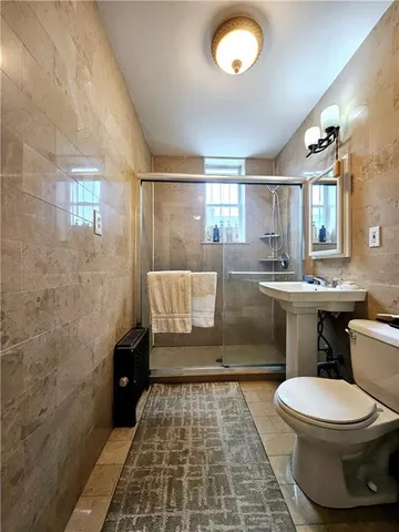 a bathroom with a toilet a sink and mirror