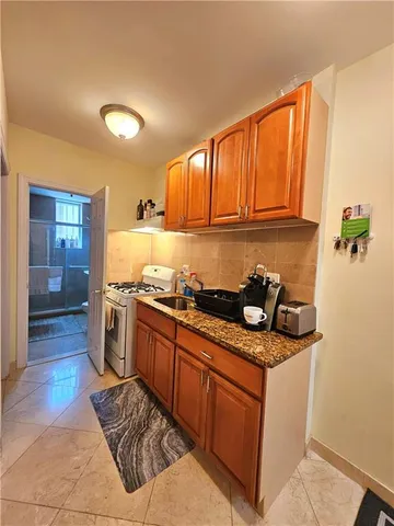 a kitchen with granite countertop a sink stove and cabinets