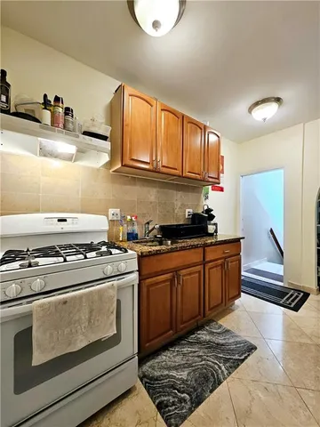 a kitchen with stainless steel appliances granite countertop a stove a sink and a refrigerator