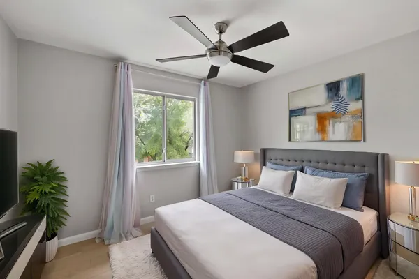 an empty room with windows and fan