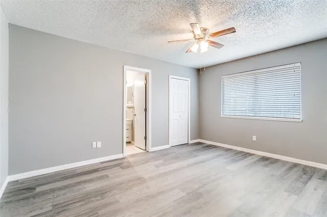 an empty room with fan and windows