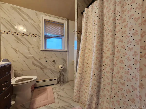 a bathroom with a toilet and a shower curtain
