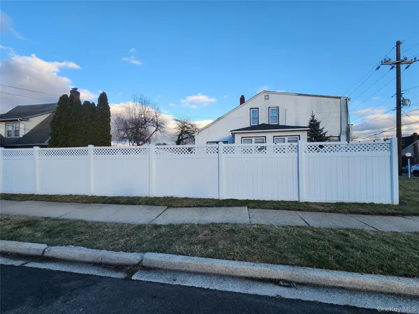 a view of a dry yard with wooden fence