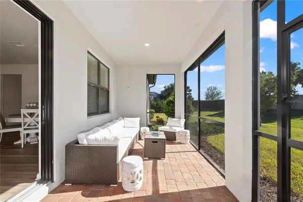 a living room with couch floor to ceiling window and wooden floor