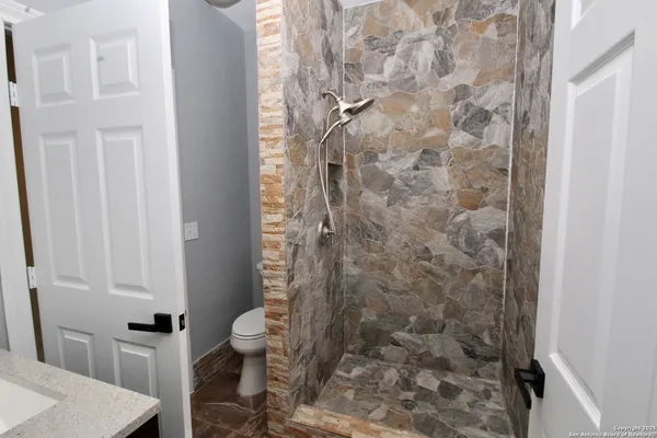 a bathroom with a toilet and a shower