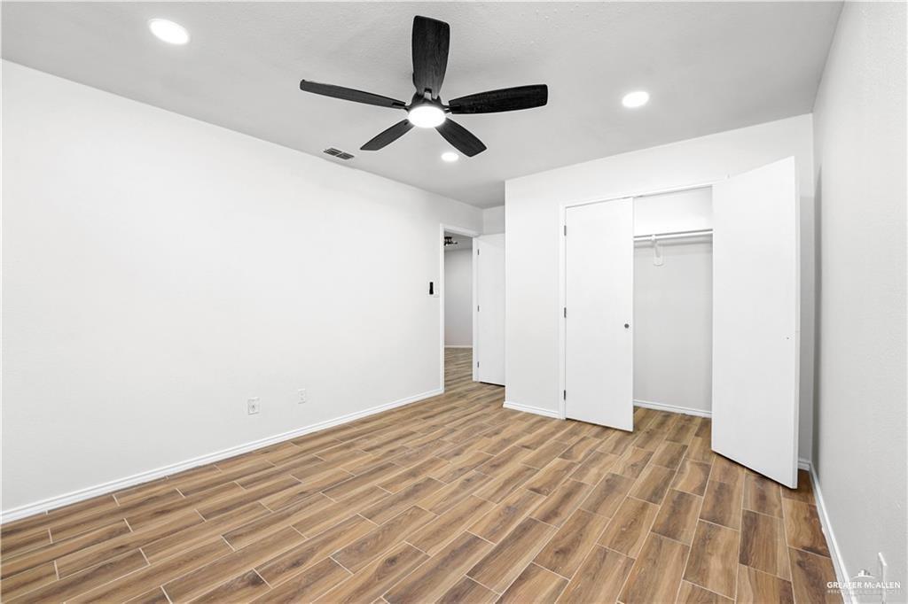 2002 West First Street Mission, TX 78572 - Photo 7 of 14 Wood-finish flooring, recessed lighting, and a ceiling fan with integrated illumination