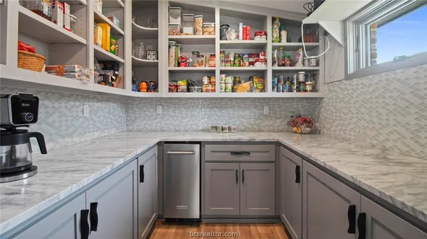 a kitchen with stainless steel appliances granite countertop a sink dishwasher and cabinets with wooden floor