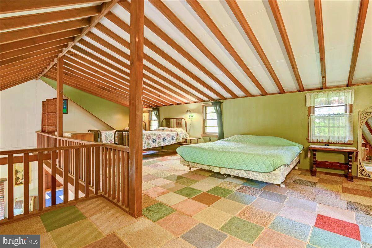 112 Beechwood Cove Road Greentown, PA 18426 - Photo 26 of 59 a bedroom with a bed and a chandelier