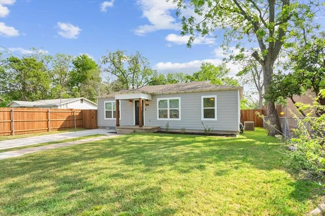 a backyard of a house with table and chairs
