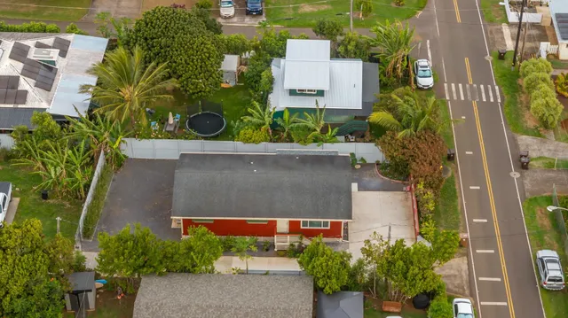 an aerial view of a house with a yard and large trees