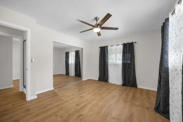 a view of a livingroom with wooden floor and a ceiling fan