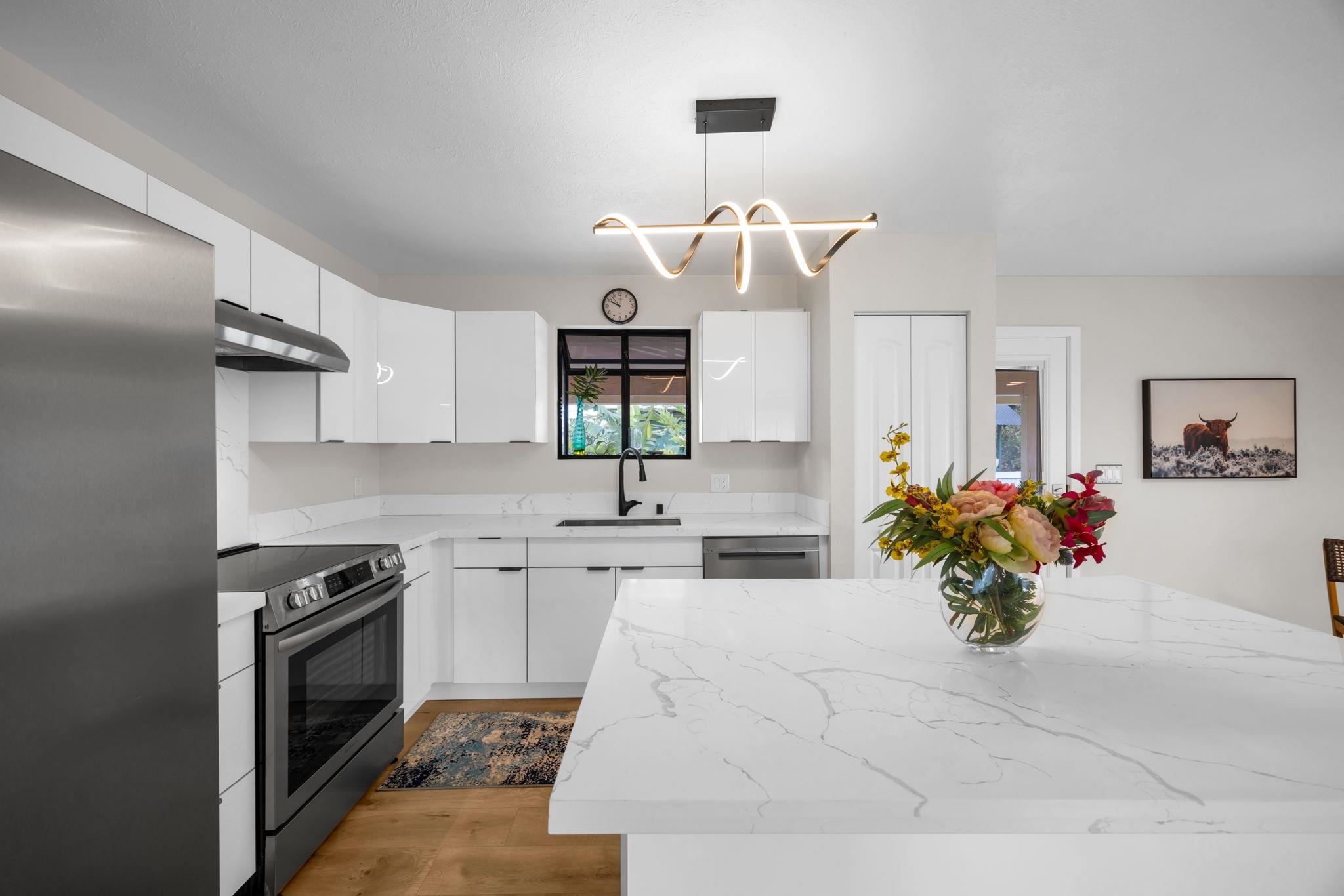 1702 Haiku Road, Unit B Haiku, HI 96708 - Photo 4 of 43 a kitchen with a stove a sink and a chandelier