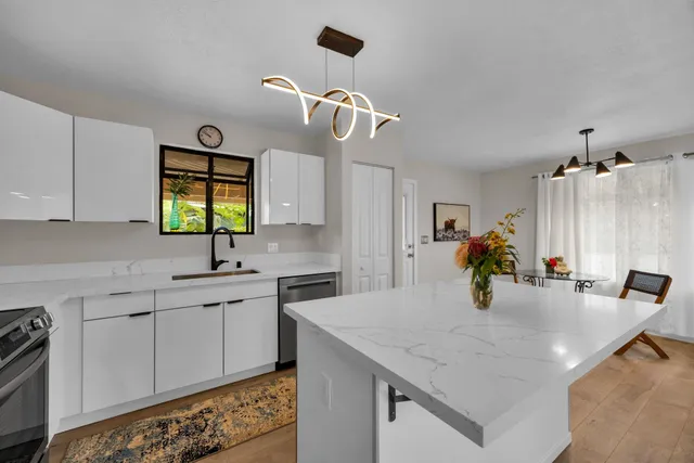 a kitchen with a sink a stove and cabinets