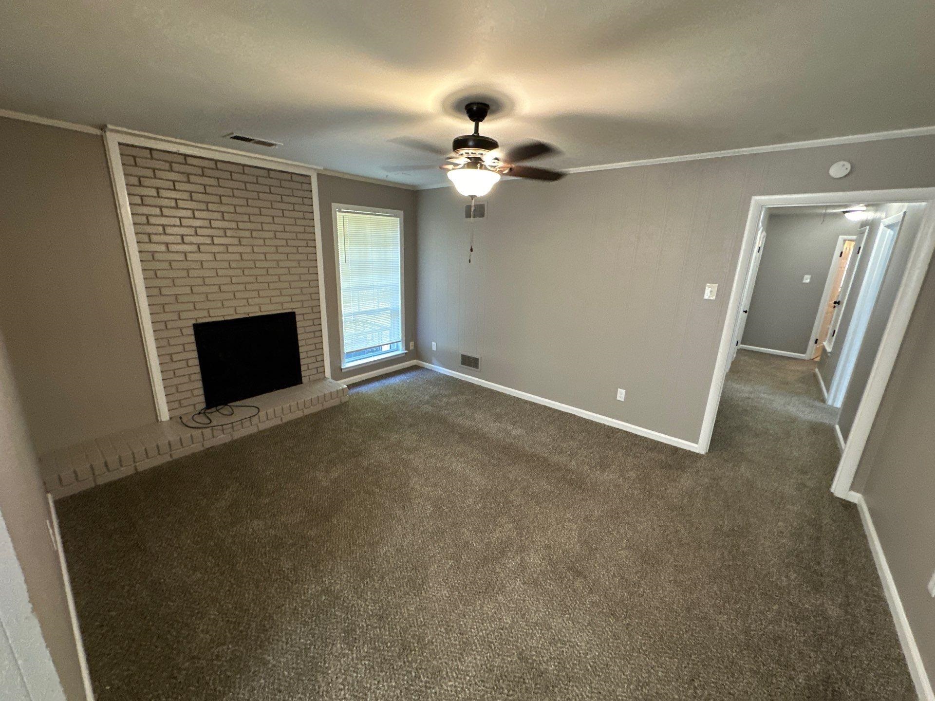 10 West Mitchell Road Memphis, TN 38109 - Photo 11 of 11 Unfurnished living room with ornamental molding, visible vents, a ceiling fan, and dark colored carpet