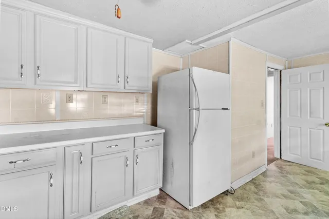 a kitchen with cabinets and a refrigerator