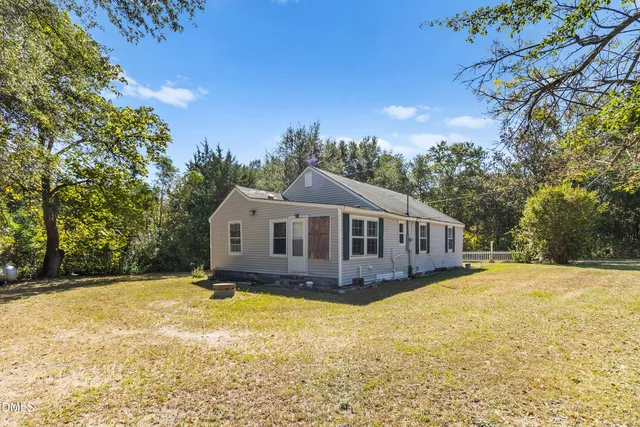 a front view of a house with a yard covered with trees
