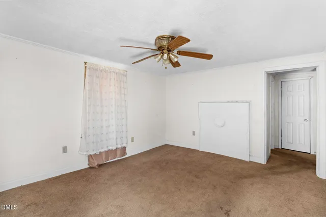 a view of a room with a hanging light and kitchen view