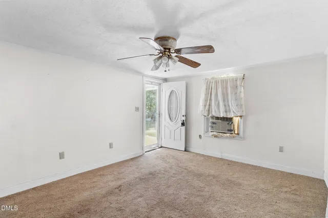 a view of a livingroom with a chandelier fan and window