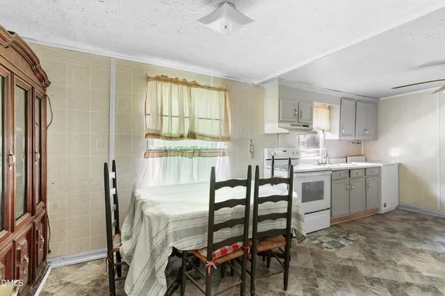 a kitchen with a table chairs refrigerator and cabinets