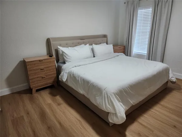 a large bed sitting in a bedroom next to a window