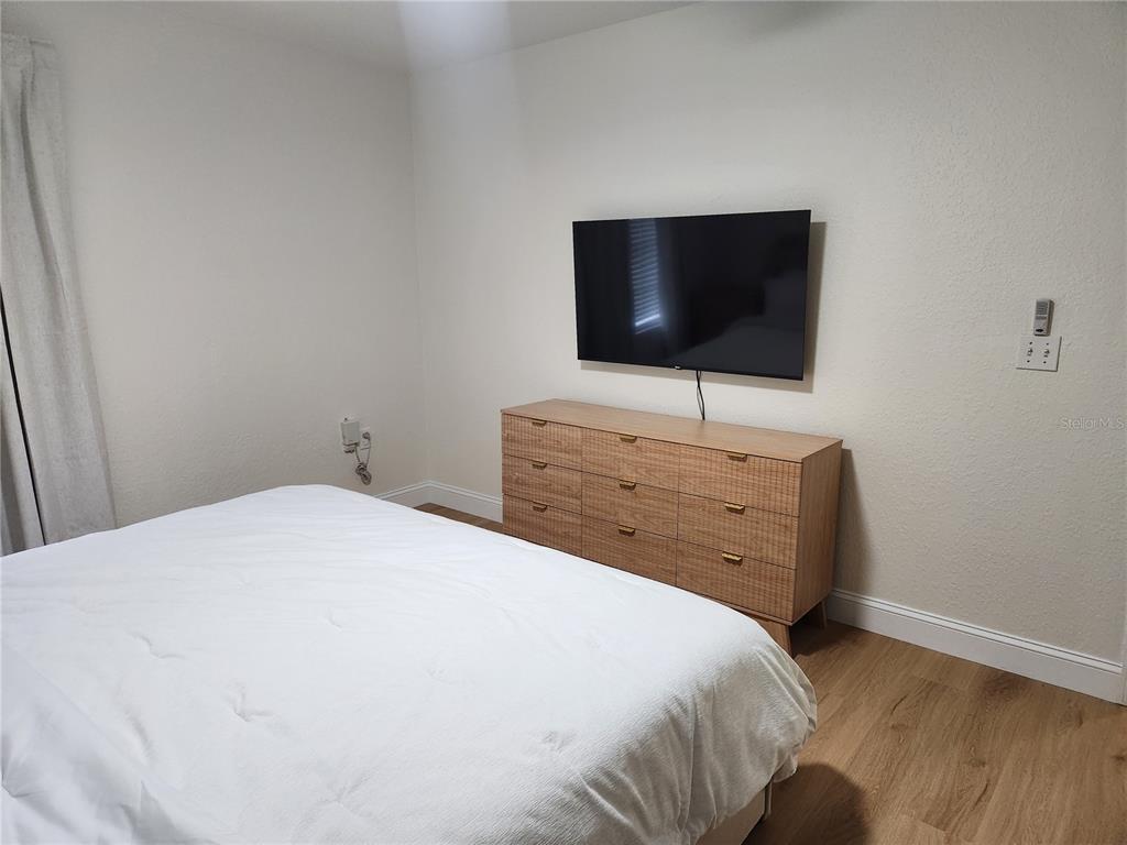 8926 Manor Loop, Unit 201B Lakewood Ranch, FL 34202 - Photo 14 of 32 a bedroom with a bed and a flat screen tv