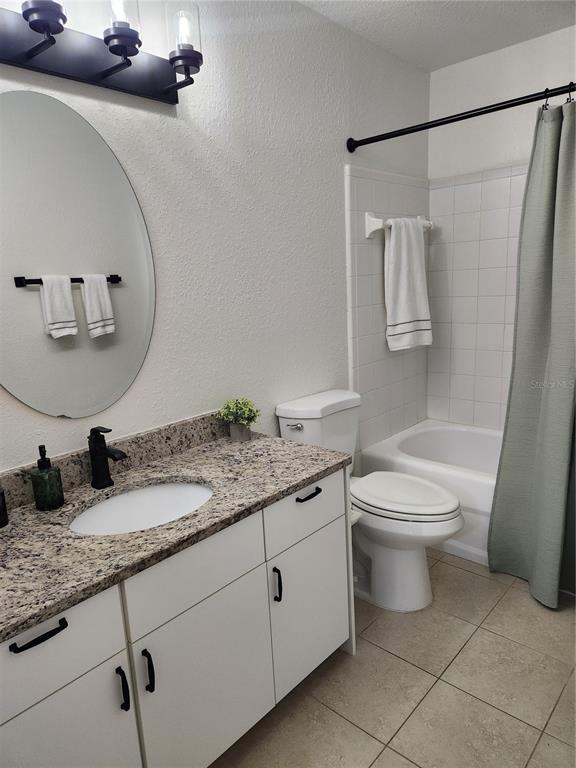 8926 Manor Loop, Unit 201B Lakewood Ranch, FL 34202 - Photo 16 of 32 a bathroom with a granite countertop toilet sink and mirror