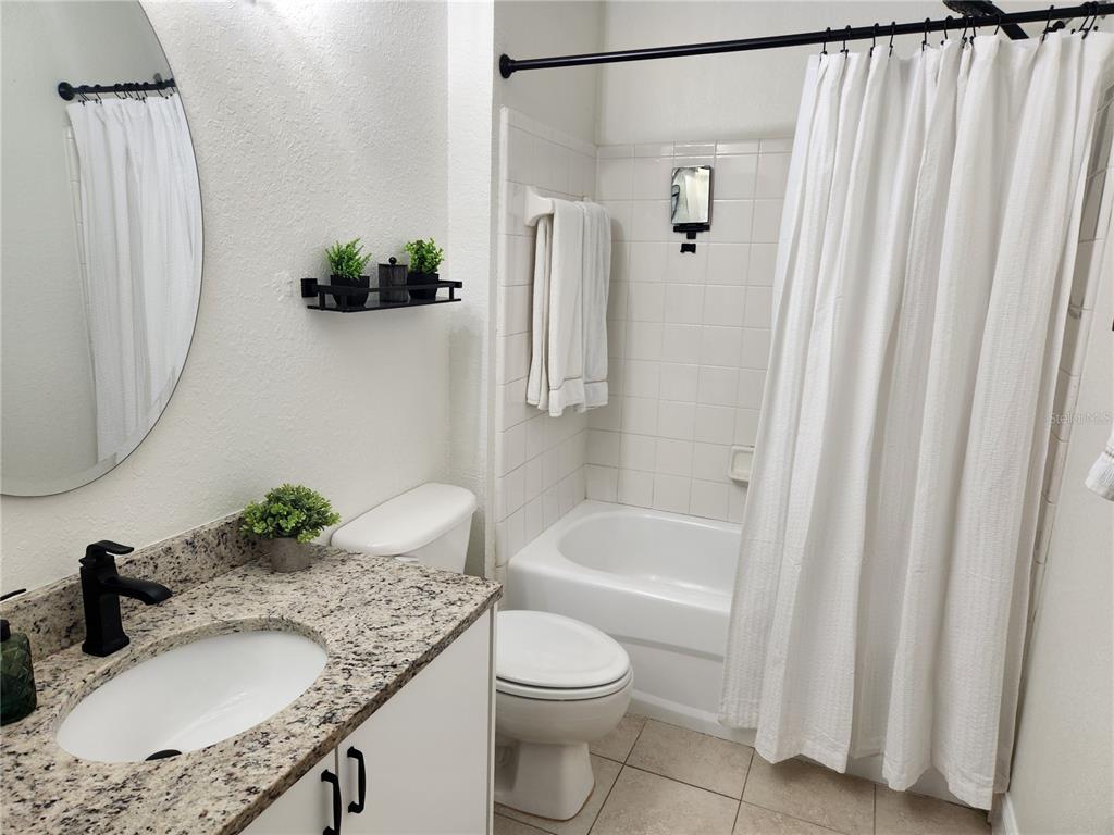 8926 Manor Loop, Unit 201B Lakewood Ranch, FL 34202 - Photo 21 of 32 a bathroom with a granite countertop sink toilet and shower