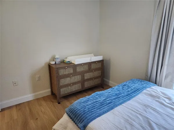 a bedroom with a bed and wooden floor