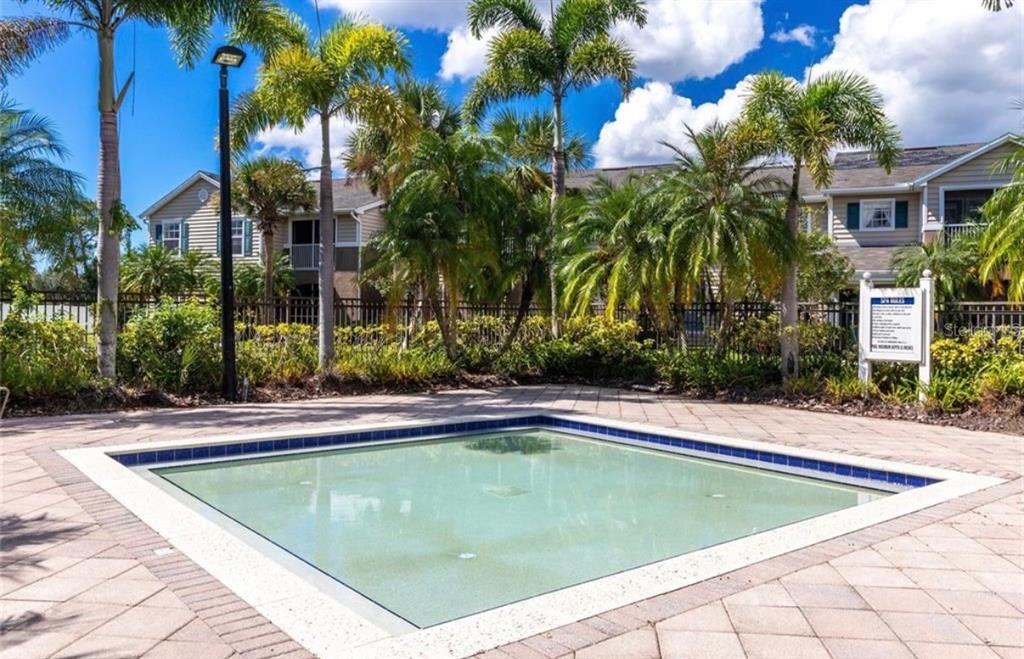 8926 Manor Loop, Unit 201B Lakewood Ranch, FL 34202 - Photo 29 of 32 a view of swimming pool with palm trees