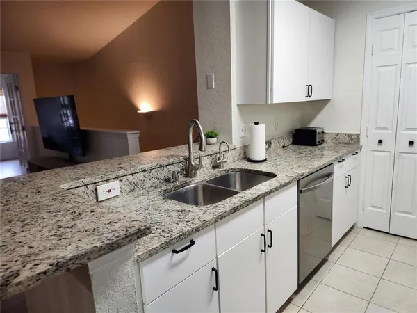 a kitchen with stainless steel appliances granite countertop a sink and dishwasher
