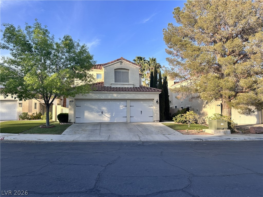 9724 Trail Rider Drive Las Vegas, NV 89117 - Photo 1 of 52 Mediterranean / spanish-style home with stucco siding, concrete driveway, a tile roof, and an attached garage