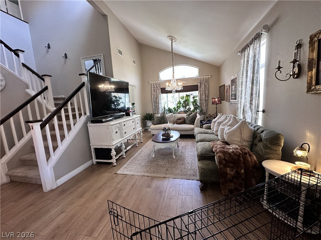 9724 Trail Rider Drive Las Vegas, NV 89117 - Photo 17 of 52 Living area with a chandelier, light wood finished floors, and vaulted ceiling