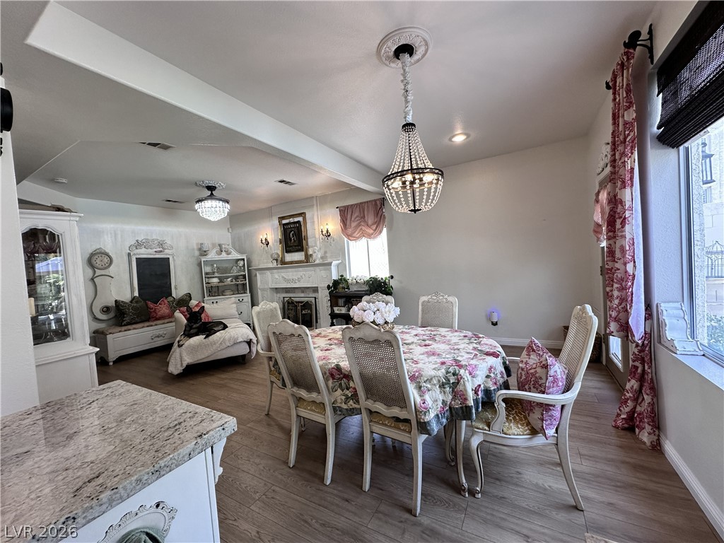9724 Trail Rider Drive Las Vegas, NV 89117 - Photo 27 of 52 Dining space featuring a fireplace, wood finished floors, and suspended lighting