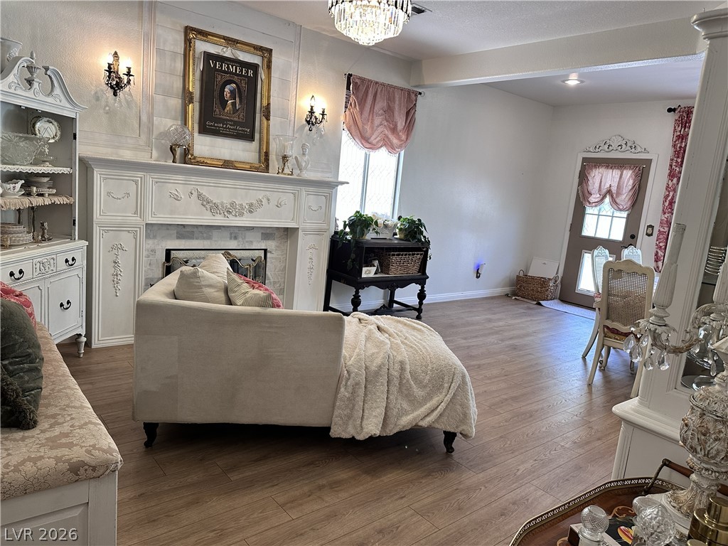 9724 Trail Rider Drive Las Vegas, NV 89117 - Photo 32 of 52 Living area with wood finished floors, a fireplace, and a chandelier