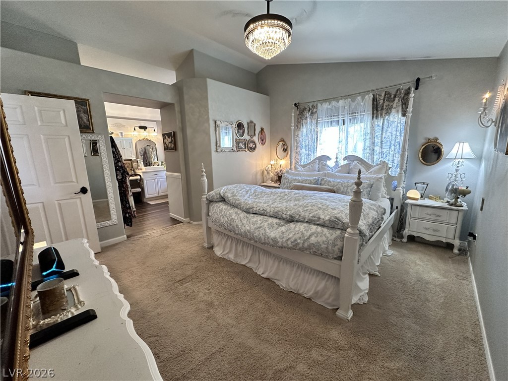9724 Trail Rider Drive Las Vegas, NV 89117 - Photo 37 of 52 Bedroom with carpet, vaulted ceiling, a chandelier, and ensuite bath