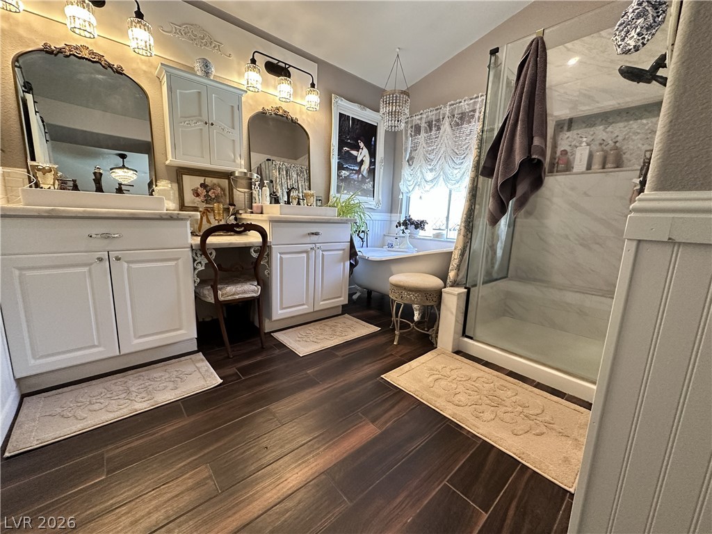 9724 Trail Rider Drive Las Vegas, NV 89117 - Photo 38 of 52 Bathroom featuring two vanities, lofted ceiling, dark wood-style flooring, a shower stall, and a freestanding tub